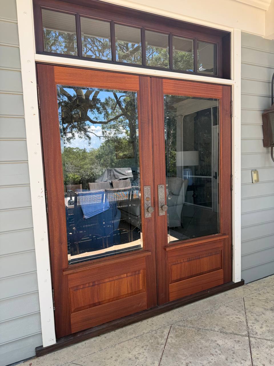 A finished pair of Sapele glass entry doors installed on a Lowcountry home