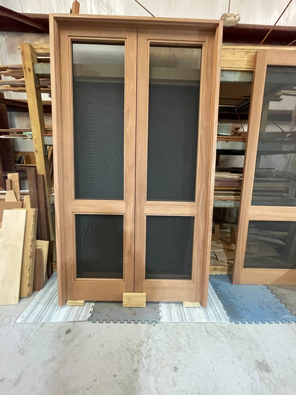 A finished pair of handcrafted Sapele screen doors in the shop
