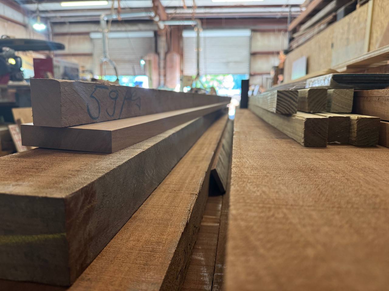 Racked Sapele lumber running the length of the shop